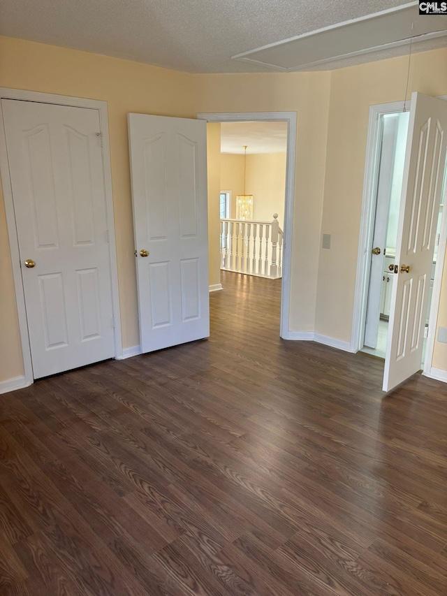 unfurnished bedroom featuring dark wood-type flooring and a textured ceiling