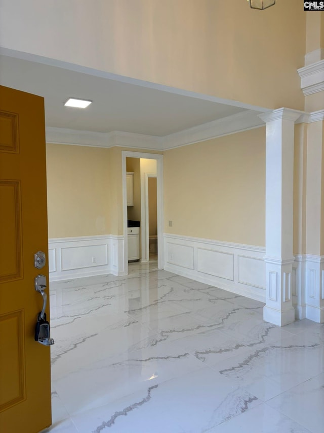 empty room featuring ornate columns, crown molding, and washer / dryer