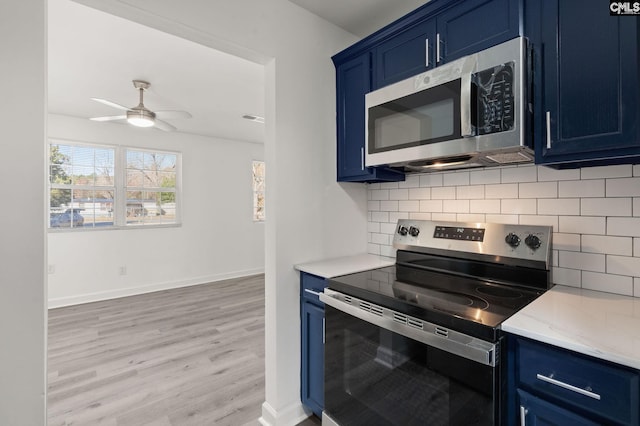 kitchen featuring tasteful backsplash, stainless steel appliances, blue cabinets, ceiling fan, and light hardwood / wood-style flooring