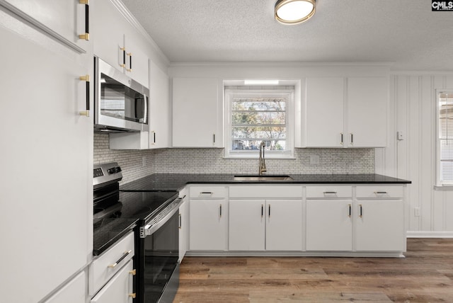 kitchen with sink, white cabinets, and appliances with stainless steel finishes