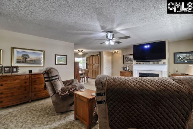 living room with a textured ceiling, ceiling fan, and light carpet