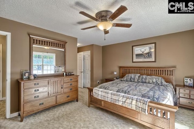 carpeted bedroom with a textured ceiling and ceiling fan