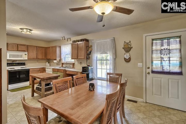 dining room featuring ceiling fan, sink, and a textured ceiling