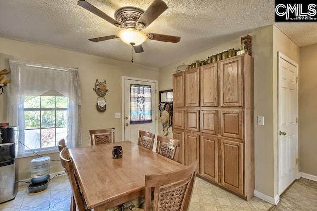 dining space featuring ceiling fan and a textured ceiling