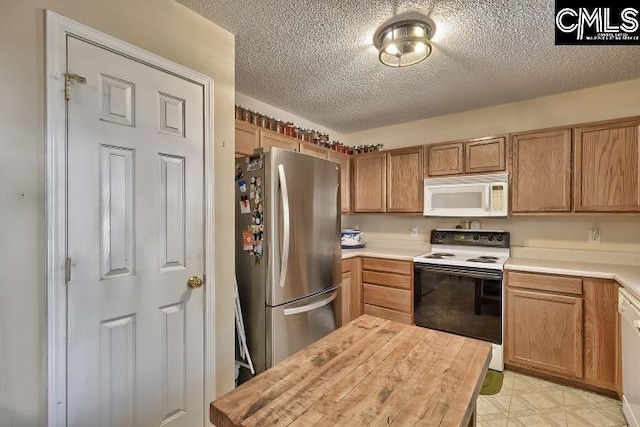 kitchen featuring a textured ceiling and white appliances