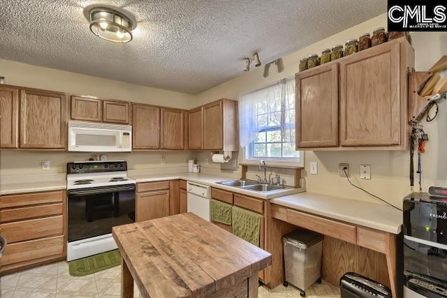 kitchen with a textured ceiling, butcher block counters, white appliances, and sink