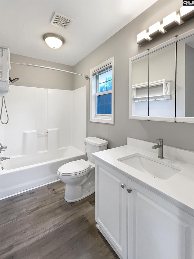 full bathroom featuring hardwood / wood-style floors, vanity, toilet, and shower / washtub combination