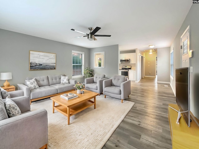 living room featuring hardwood / wood-style floors and ceiling fan