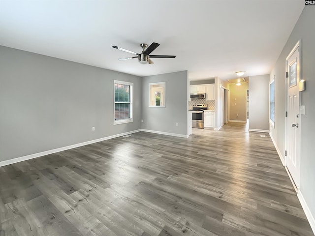 unfurnished living room with dark hardwood / wood-style floors and ceiling fan