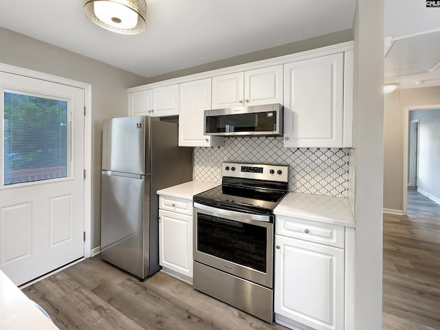 kitchen featuring white cabinets, decorative backsplash, light hardwood / wood-style floors, and appliances with stainless steel finishes