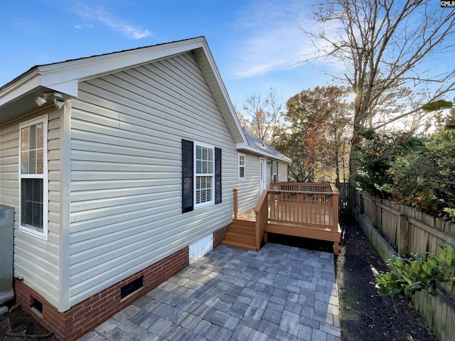 view of property exterior featuring a deck and a patio