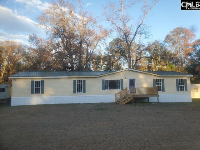 manufactured / mobile home with a front yard and a deck