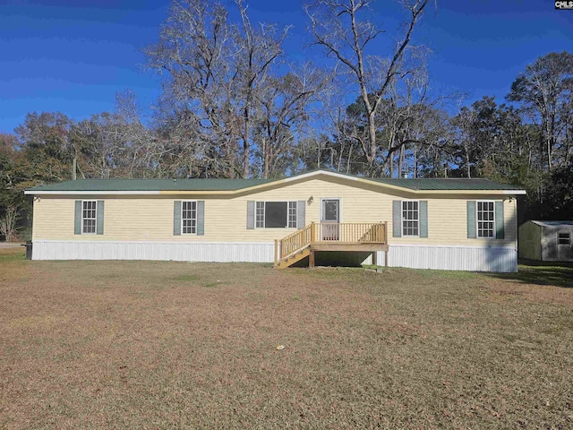 manufactured / mobile home featuring a front lawn and a storage shed