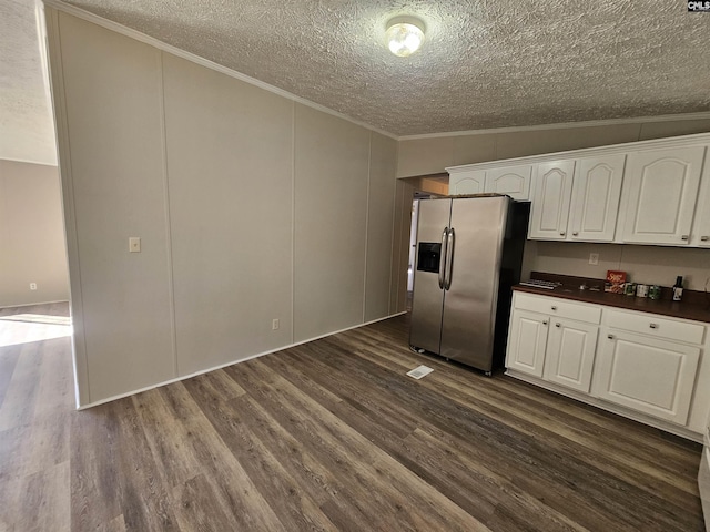 1611 Carolina Ln, Beaufort, SC 29906 - kitchen with white cabinetry, dark wood-type flooring, stainless steel fridge with ice dispenser, crown molding, and a textured ceiling