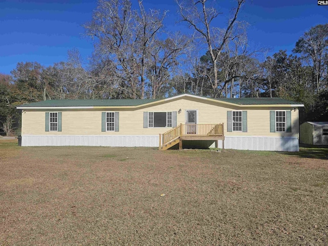 manufactured / mobile home with a wooden deck and a front lawn