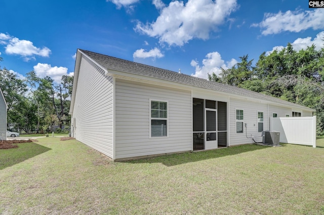 rear view of house with a lawn and cooling unit