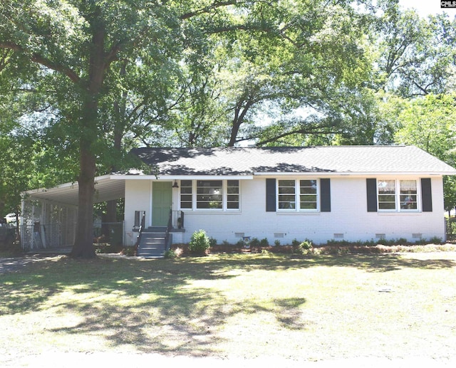 ranch-style home featuring a front lawn and a carport