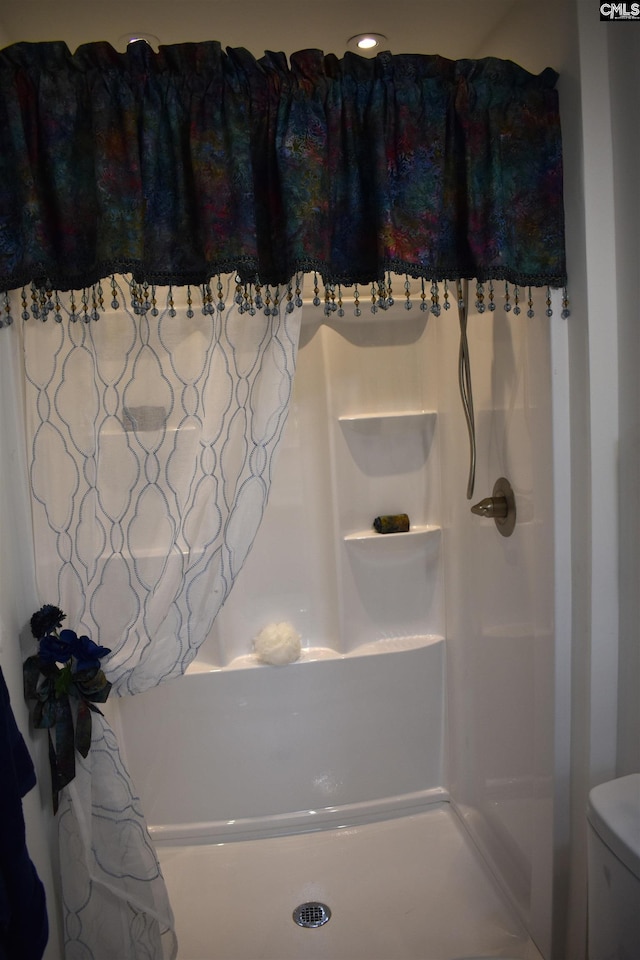 bathroom with curtained shower and toilet