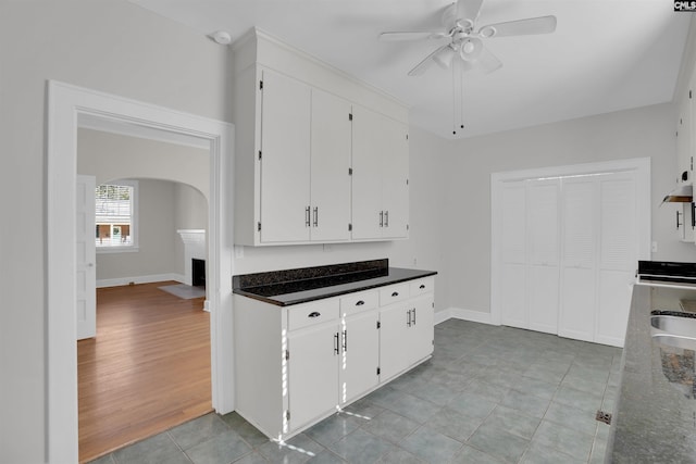 kitchen featuring light hardwood / wood-style floors, white cabinetry, ceiling fan, and sink