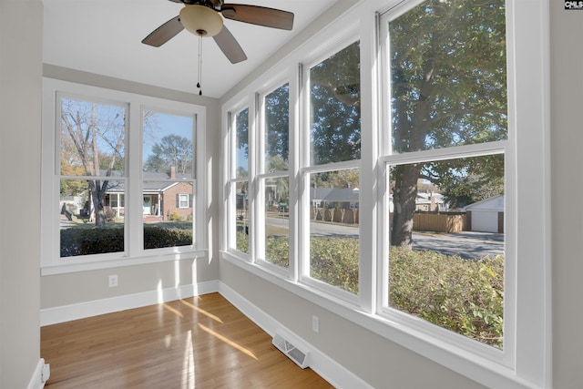 unfurnished sunroom featuring ceiling fan