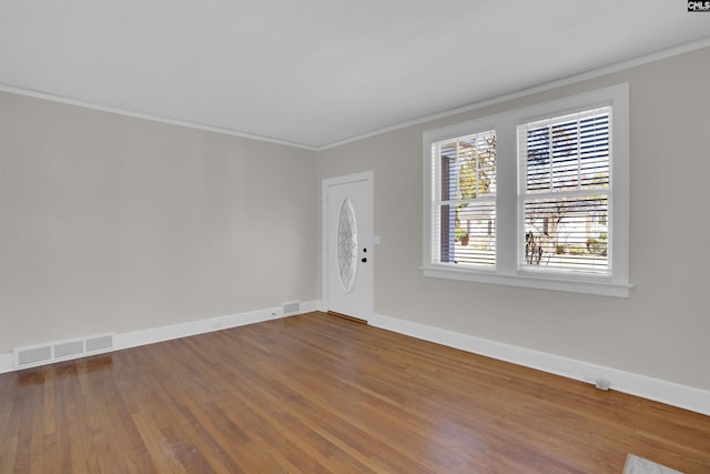 empty room featuring hardwood / wood-style flooring and crown molding