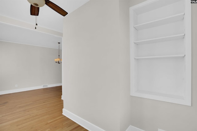 hallway featuring hardwood / wood-style floors and a notable chandelier