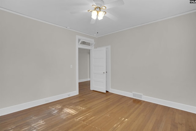 empty room featuring hardwood / wood-style flooring, ceiling fan, and crown molding