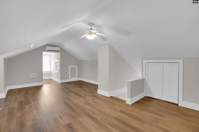 bonus room with hardwood / wood-style flooring, ceiling fan, a wall mounted air conditioner, and vaulted ceiling