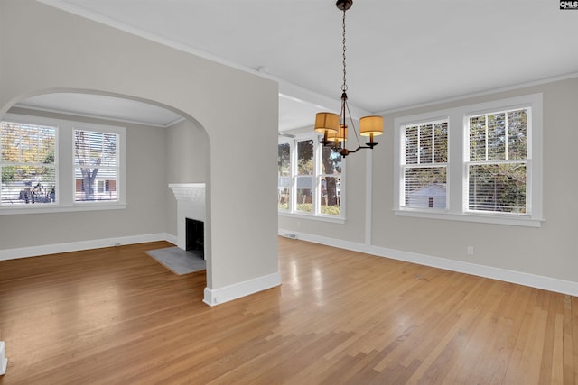 unfurnished dining area with crown molding, light hardwood / wood-style flooring, and a chandelier