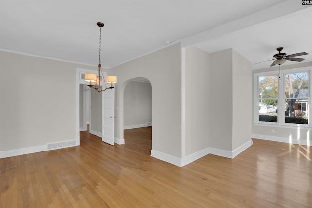 empty room with wood-type flooring, ceiling fan with notable chandelier, and ornamental molding