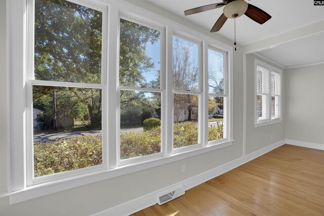 unfurnished sunroom with ceiling fan