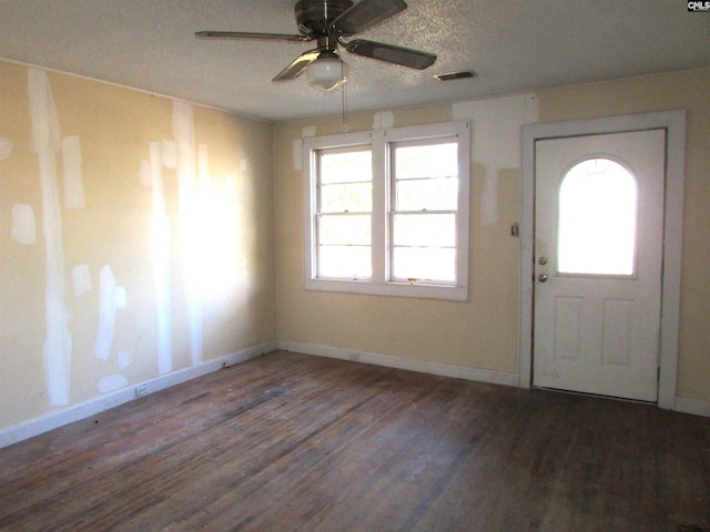 foyer with ceiling fan, dark hardwood / wood-style flooring, and a textured ceiling