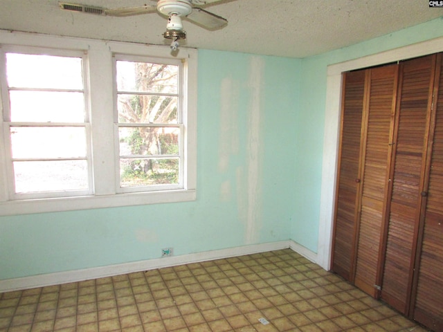 unfurnished bedroom featuring ceiling fan, a textured ceiling, and a closet