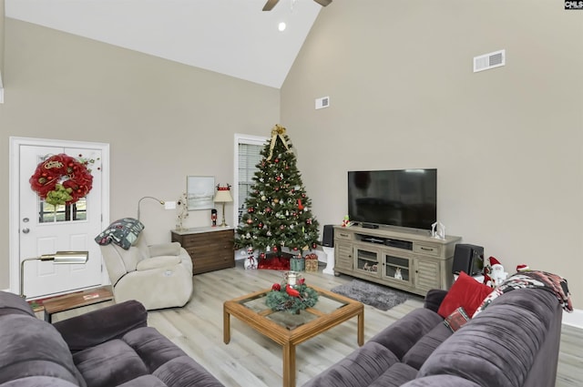 living room featuring light hardwood / wood-style flooring, high vaulted ceiling, and ceiling fan