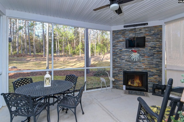 sunroom / solarium featuring ceiling fan, wood ceiling, and a fireplace