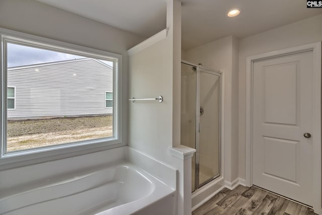 bathroom with wood-type flooring and plus walk in shower