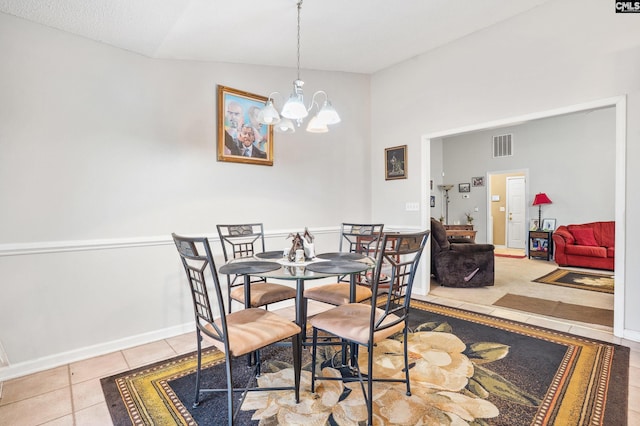 tiled dining space with a chandelier and vaulted ceiling