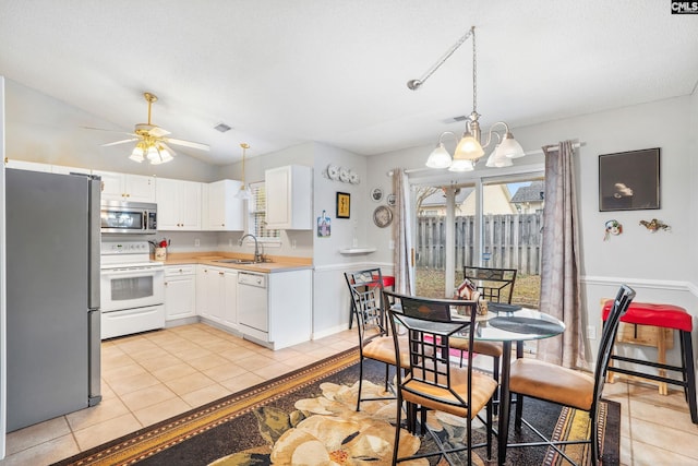 kitchen featuring white cabinets, pendant lighting, stainless steel appliances, and sink