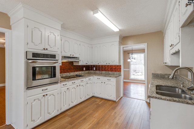 kitchen with oven, light wood-type flooring, white cabinetry, and sink