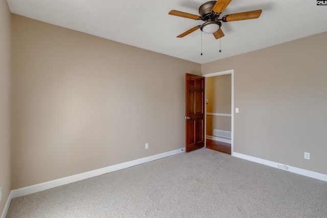 empty room with ceiling fan and light carpet