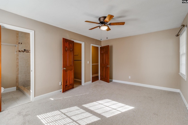 unfurnished bedroom with light colored carpet, ceiling fan, and ensuite bathroom