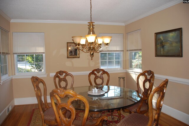 dining area with wood-type flooring, ornamental molding, and a wealth of natural light