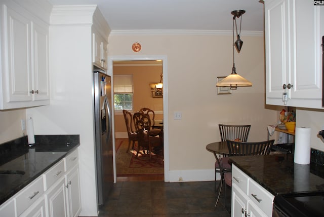 kitchen featuring white cabinets, decorative light fixtures, stainless steel fridge, and dark stone countertops