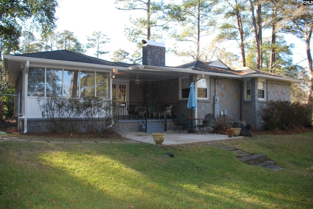 back of house featuring a lawn and a patio