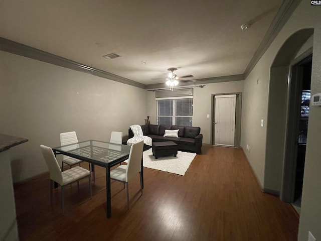 dining room with ornamental molding, ceiling fan, and dark hardwood / wood-style flooring