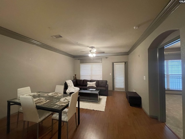 dining space with crown molding, dark wood-type flooring, and ceiling fan