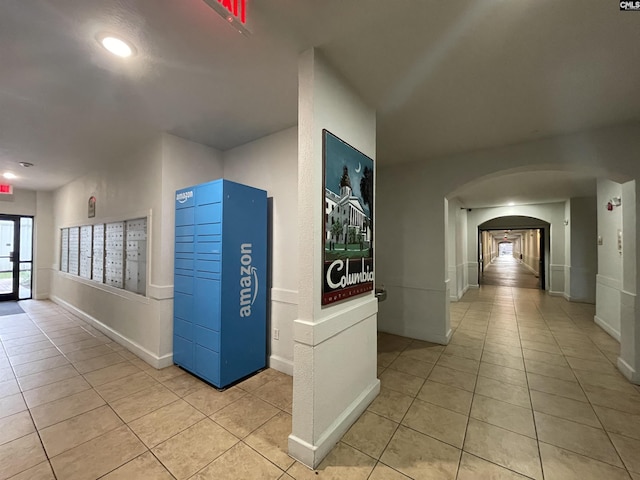 hall with light tile patterned floors and a mail area