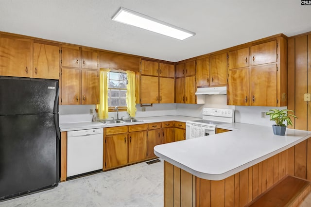 kitchen with sink, white appliances, and kitchen peninsula