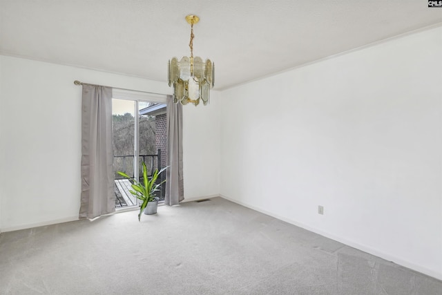 carpeted empty room featuring a chandelier