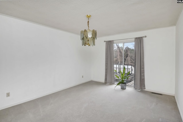 unfurnished room featuring carpet, a textured ceiling, and a notable chandelier